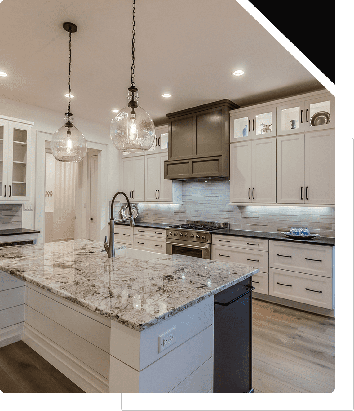 Modern kitchen with marble island and lighting.